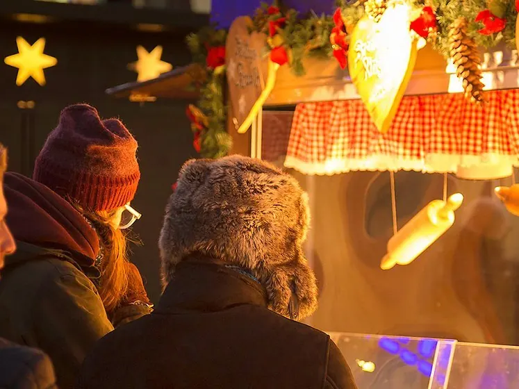 Amici a una bancarella del mercatino di Natale la sera